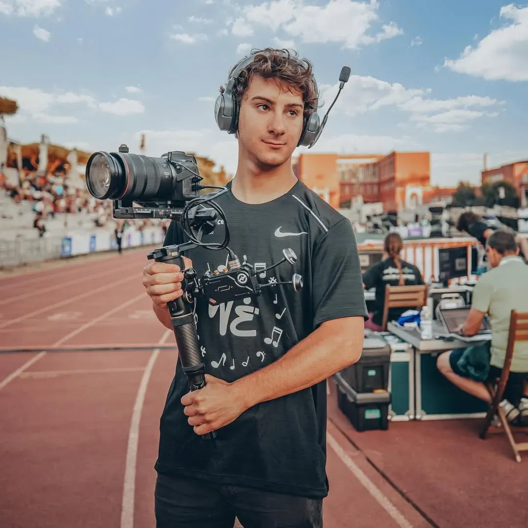 Videomaker Amedani durante riprese in evento sportivo per video marketing e contenuti social media